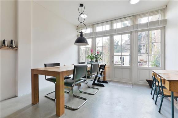 Grote industriële zwarte hanglamp boven houten eettafel Grote industriële zwarte hanglamp boven houten eettafel