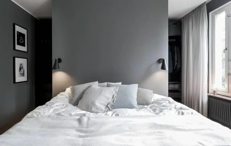 Strakke slaapkamer met antraciet muren en een strak wit plafond.