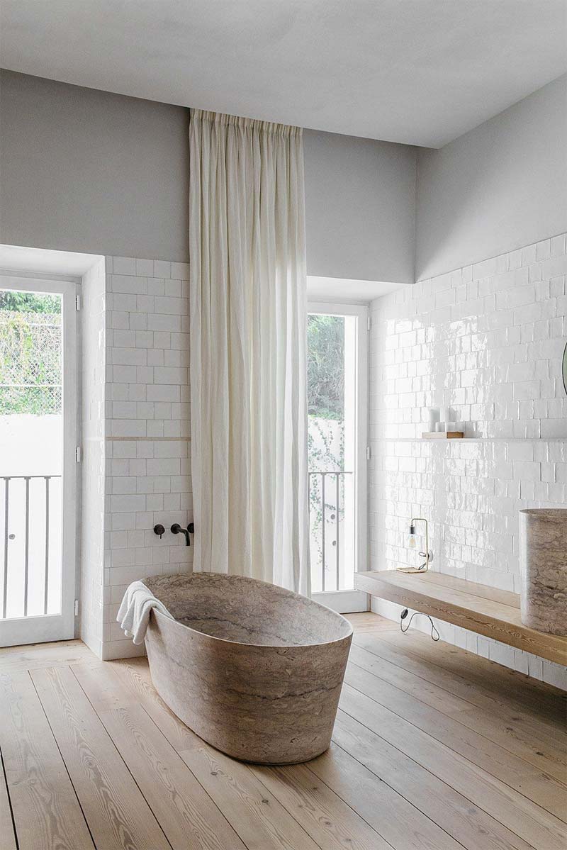 Prachtige badkamer met een houten vloer, betegelde wanden en een stijlvol tadelakt plafond.