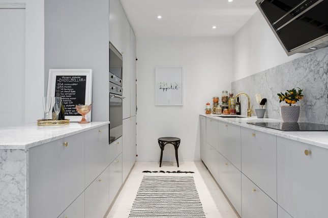 Smalle keuken met grijze kasten aan twee kanten Smalle keuken met grijze kasten aan twee kanten