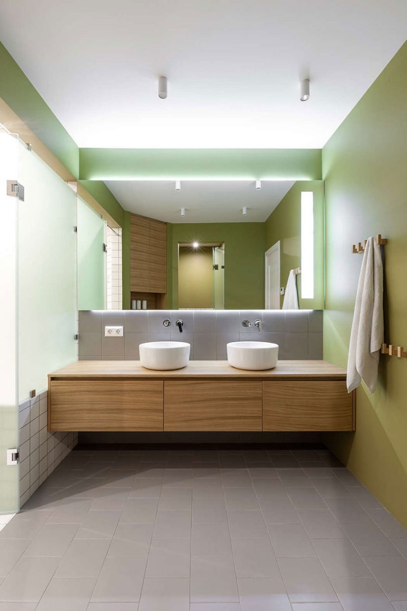 Grijze vloertegels en groene muren in moderne badkamer