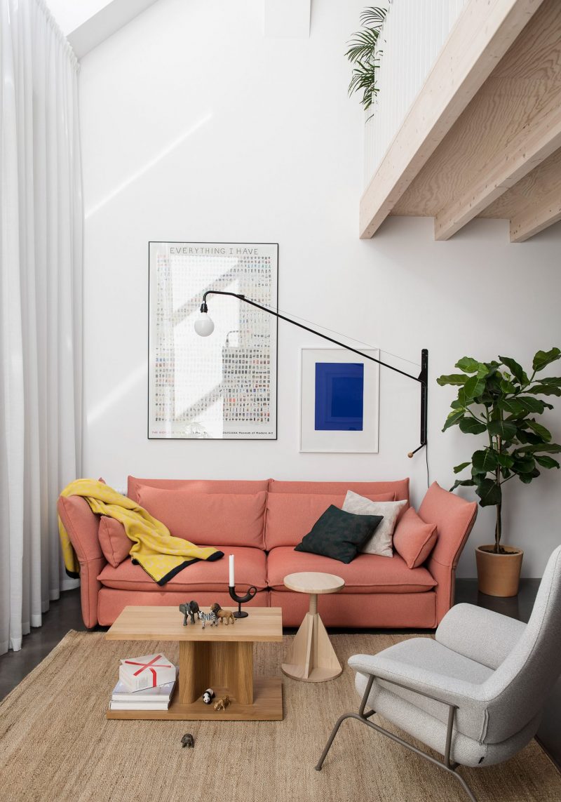 Knusse zithoek met jute vloerkleed, houten salontafel en roze bank Knusse zithoek met jute vloerkleed, houten salontafel en roze bank