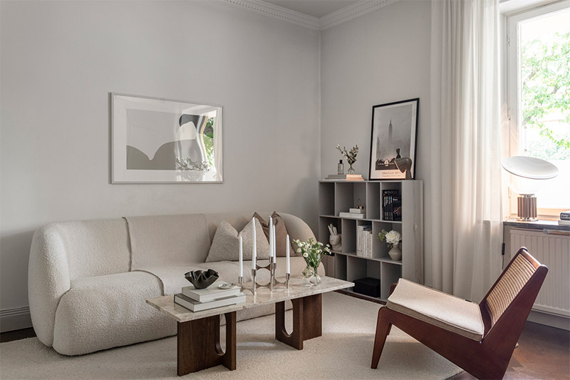 In deze mooie woonkamer is een grote vakkenkast als dressoir in de hoek geplaatst, naast de bank.