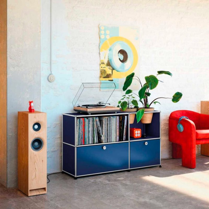 In deze stoere woonkamer is de USM Haller Planten Sideboard dressoir tegen de witte bakstenen muur geplaatst, en wordt gebruikt als een stoere platenkast. Hier verkrijgbaar voor € 1.766.