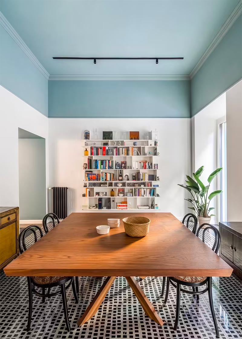 Deze mooie woonkeuken is ontworpen door Studio Tamat, die het hoge plafond optisch heeft verlaagd door de rand van de muren in dezelfde mooie blauwe kleur te verven als het plafond. | Fotografie: Seven H Zhang