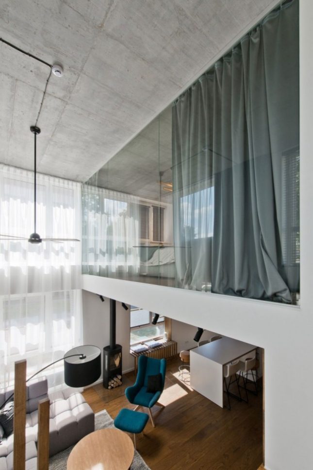 Glazen wand in slaapkamer biedt uitzicht op woonkamer