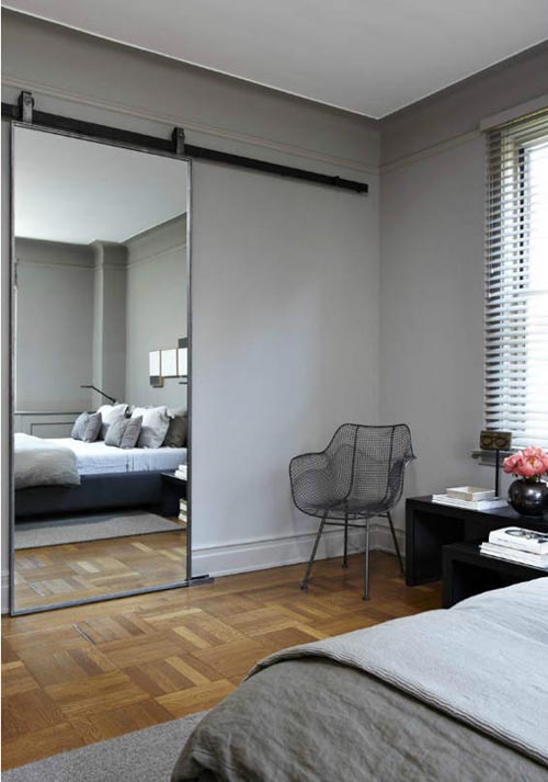 Slaapkamer met houten vloer en spiegelschuifdeur