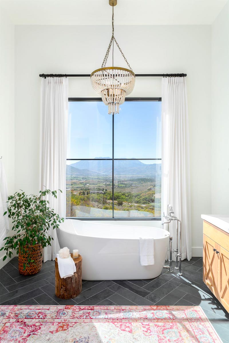 In deze chique badkamer voegt het grote vintage vloerkleed een vleugje kleur en vintage charme toe.