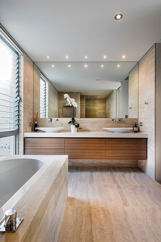 Grote spiegelwand opmaat boven zwevende badkamermeubel van hout