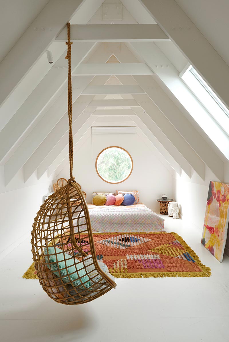 Een super leuke rotan hangstoel in een witte knusse slaapkamer op zolder | Fotografie: N. Ramsey | Bron: Thegracetales.com
