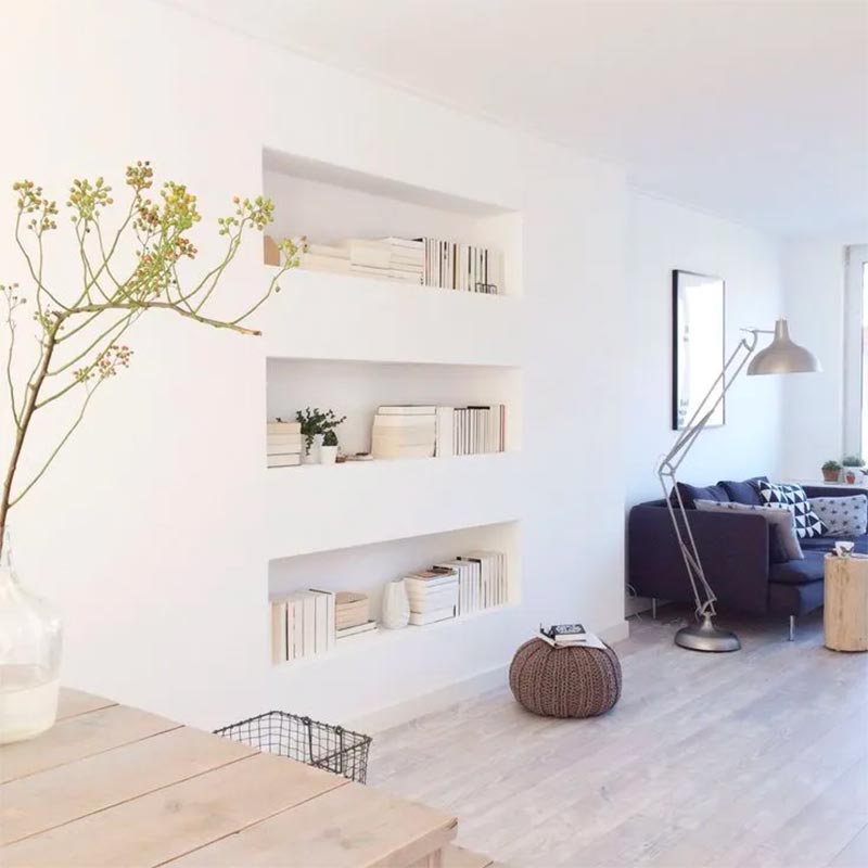 Blogger Vanessa Barendregt creëerde drie strakke inbouw nissen in haar woonkamer, die ze als open boekenkast gebruikt.