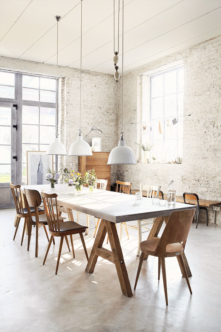 Stoere industriële hanglampen boven grote betonnen eettafel Stoere industriële hanglampen boven grote betonnen eettafel