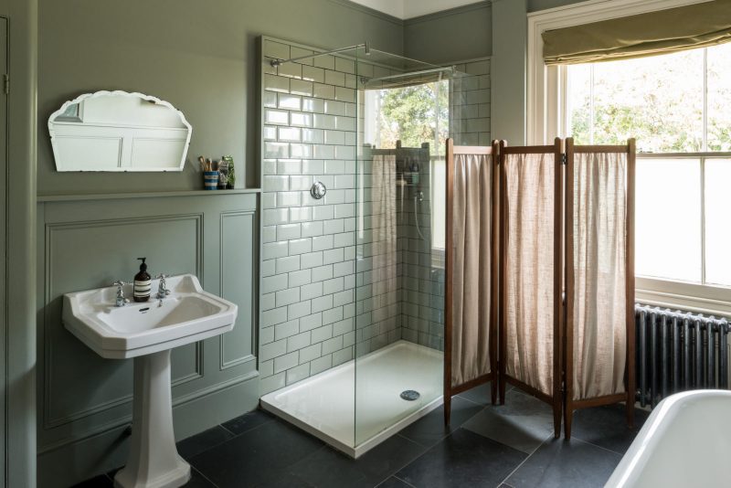 Inloopdouche met douchebak in klassieke badkamer met mosgroene muren