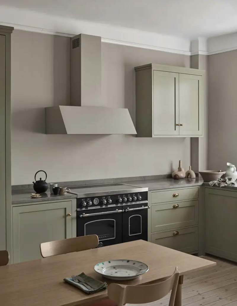 In plaats van witte muurverf, kan je ook een andere mooie kleur uitkiezen. In deze mooie keuken is er een mooie grijs-beige kleur gekozen, passend bij de groene keuken.
