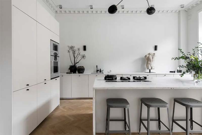 Strakke witte keuken met een strakke witte keuken achterwand.