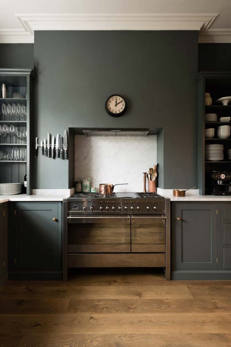 In deze DeVol keuken is een mosgroen geverfde keuken achterwand gecombineerd met een marmeren spatwand.