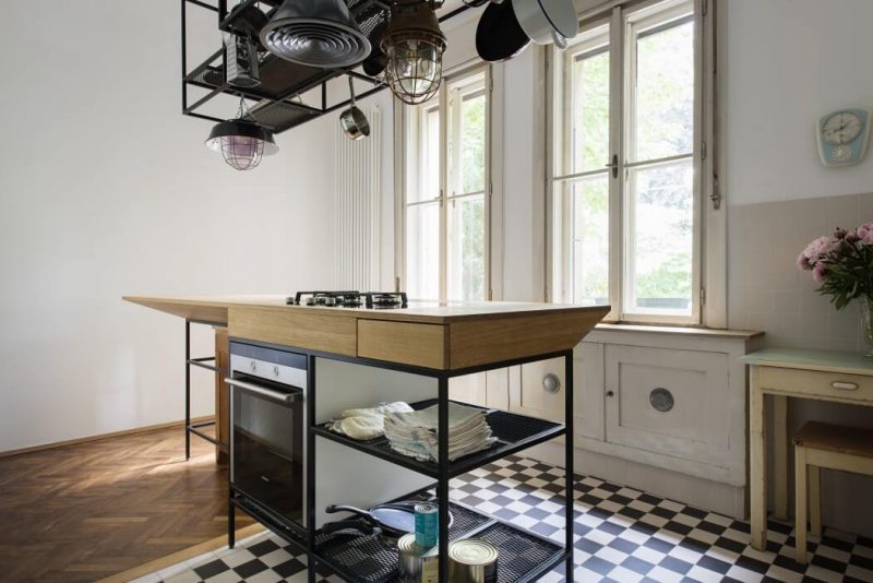 Smal modern kookeiland met rek met hangende pannen Smal modern kookeiland met rek met hangende pannen