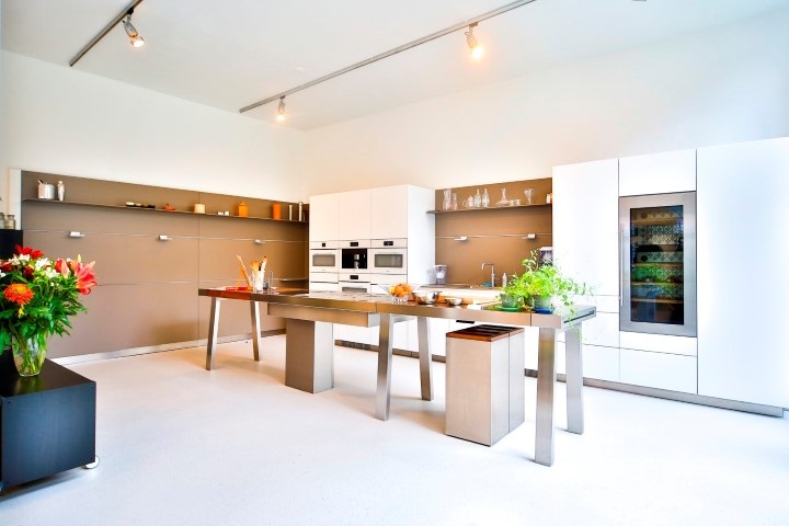 Mooie lichte troffelvloer in een strakke moderne keuken met witte keukenkasten en eiland.