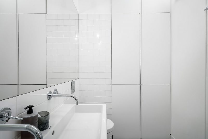 Strakke witte inbouwkast in kleine badkamer