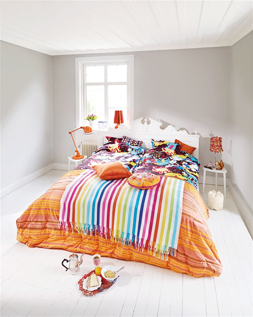 Witte slaapkamer met kleurrijk beddengoed