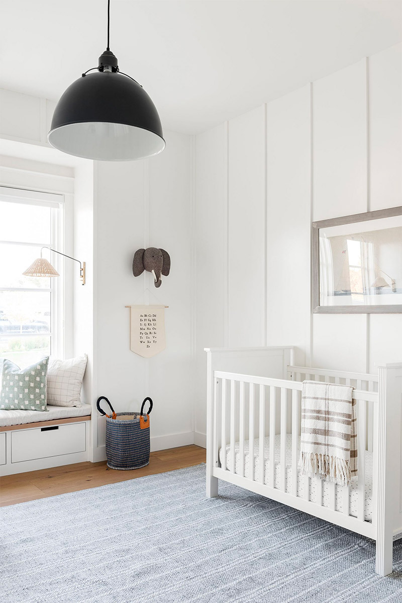 Een babykamer ontwerp door Studio Mcgee.com - met leuke decoratie, zoals de knuffelolifant en de wandhanger aan de muur naast het raam. | Bron: Studio-mcgee.com