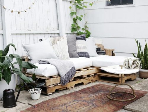 Leuke tuin met een loungebank van houten paletten