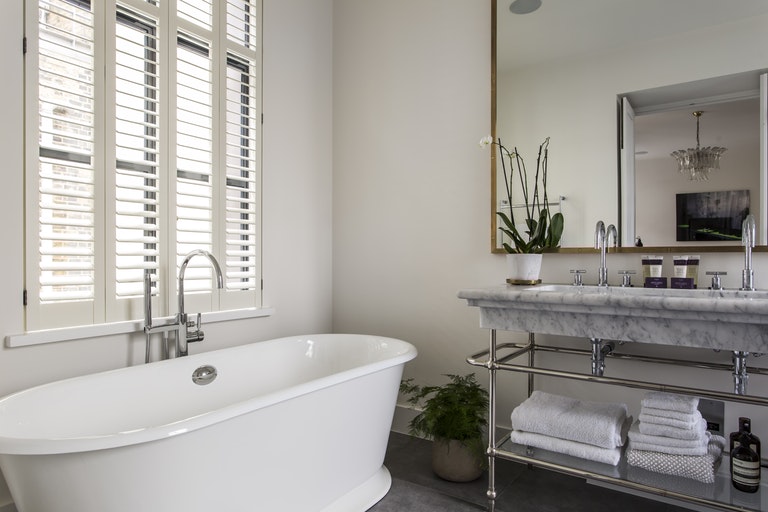 De leuke planten maken deze luxe badkamer af, die ontworpen is door K&L Interiors.