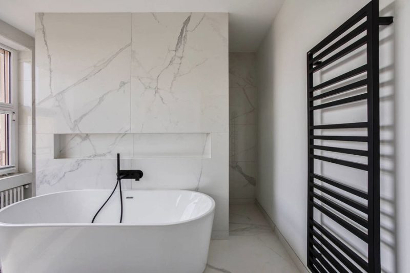 Frans ontwerpbureau Eva Myard Interior heeft deze luxe badkamer ontworpen, waar een scheidingsmuur het vrijstaande bad en de inloopdouche van elkaar scheidt.