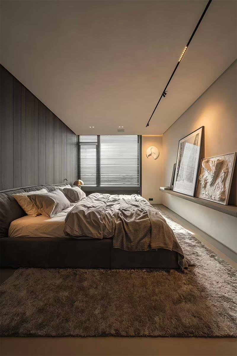Yodezeen Architects heeft deze luxe slaapkamer ontworpen, waar de grote wand volledig bekleed is met luxe houten wandbekleding.