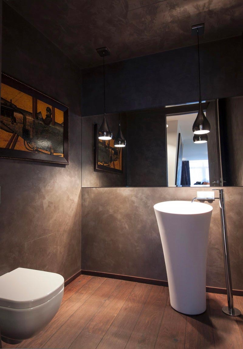 luxe toilet met houten vloer en betonstuc wanden
