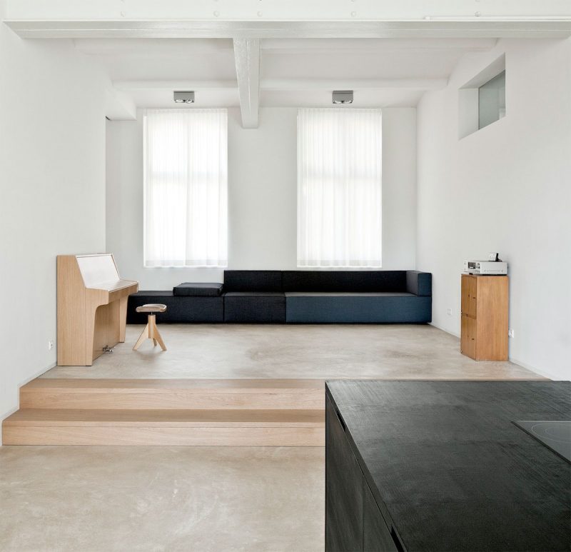 De strakke gietvloer in deze moderne minimalistische woonkamer heeft een warme ondertoon. Daarbij is een echte blauwe bank als eyecatcher gekozen. Klik hier voor meer foto's.