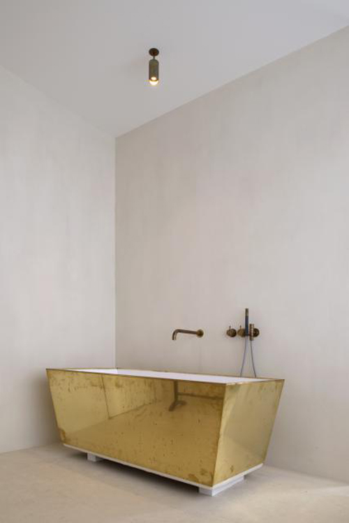 Vintage gouden bad in minimalistische badkamer