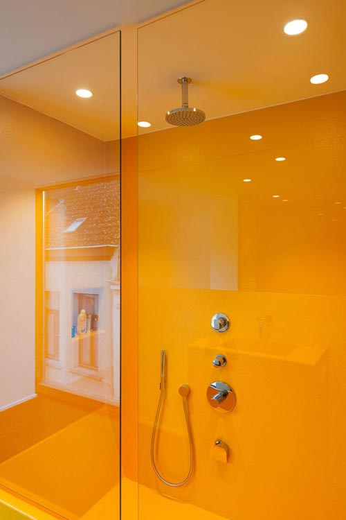 Gele muren en vloer in ruime inloopdouche