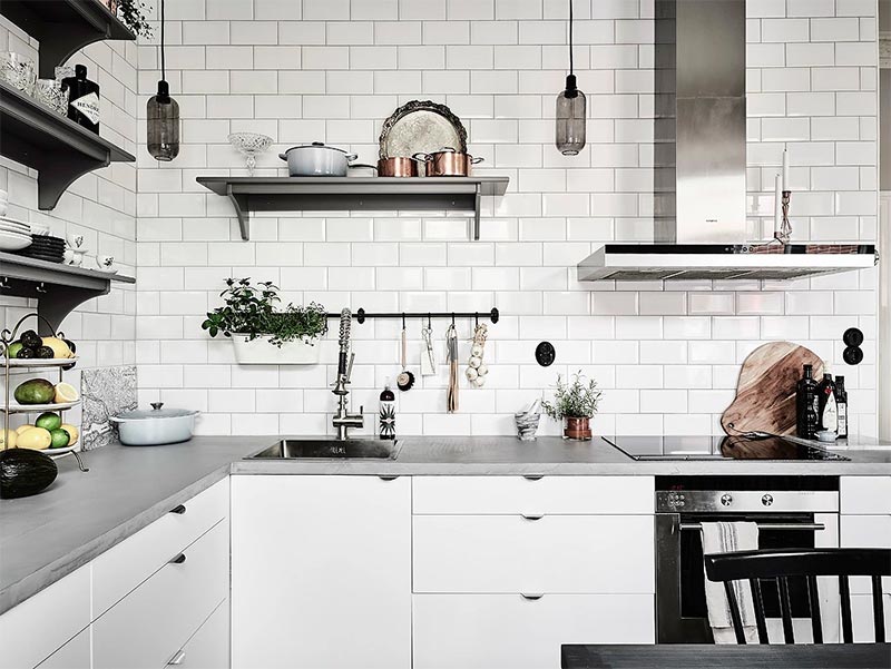 Hier zijn strakke witte keukenkasten gecombineerd met een dun betonnen keukenblad.