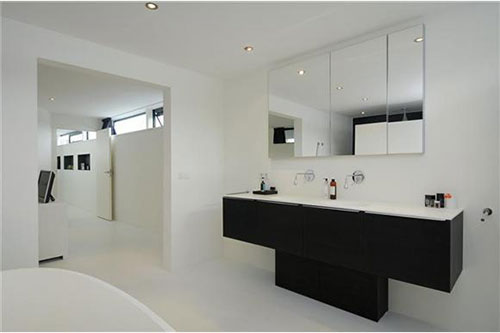 Strakke zwarte badkamermeubel in witte badkamer