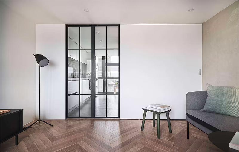 Stalen deuren met glas zijn een populaire keuze tussen de keuken en de woonkamer - hier te zien in een interieur ontworpen door A Little Design.