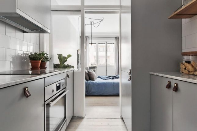 Smalle keuken met grijze kasten aan twee zijden Smalle keuken met grijze kasten aan twee zijden