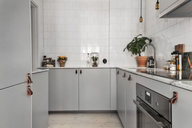 Chique vintage keuken met marmeren werkblad, grijze kasten en leren deurgrepen