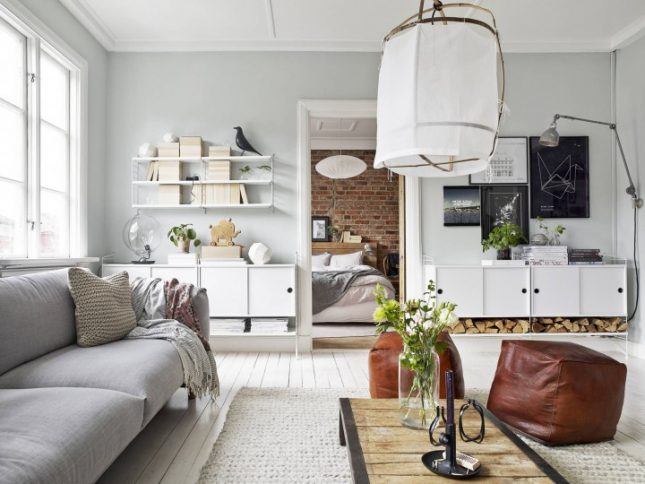 Een knus en gezellig Scandinavisch interieur, met lichtgrijze muren, witte houten vloer en stijlvolle meubels en accessoires.