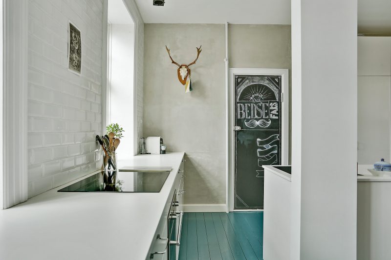 Scandinavische keuken met blauwe vloer en betonstuc wand Scandinavische keuken met blauwe vloer en betonstuc wand
