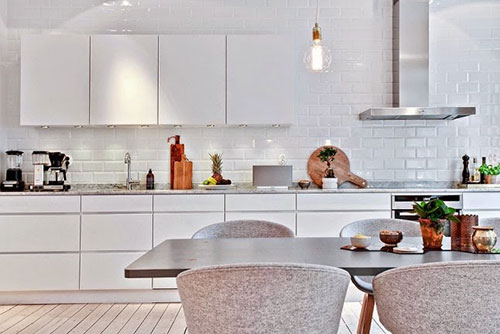 Witte moderne keukenkasten en wandkasten, en witte metro tegels aan de keuken achterwand