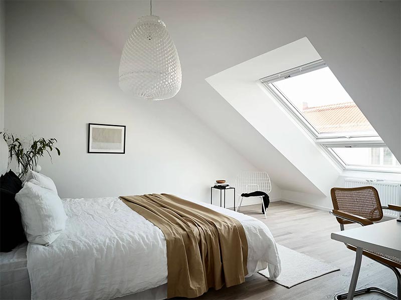 Deze slaapkamer is een stuk lichter en ruimtelijker met een groot dakraam in de schuine muur.