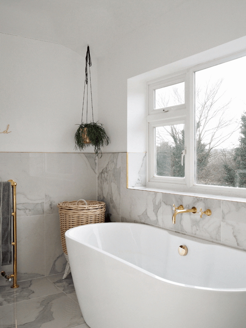 Vrijstaand bad bij het raam in luxe badkamer