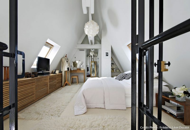 Slaapkamer vide loft Parijs met houten kasten onder schuine wand