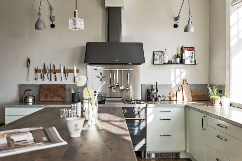 In deze stoere vintage keuken hebben ze de mintgroene kasten gecombineerd met een betonnen werkblad, een laag betonnen keuken actherwand en een stoere RVS spatwand boven het zwarte fornuis. Klik hier voor meer foto's.