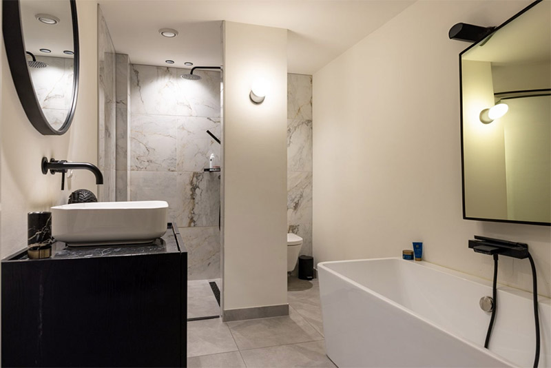 In deze luxe badkamer zijn twee spiegels opgehangen, ook boven het bad!