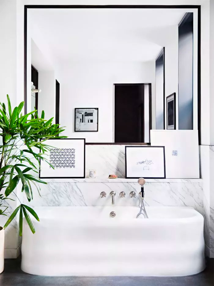 Deze grote spiegel op maat zorgt voor heel veel ruimtelijkheid in deze badkamer. | Fotografie: Brittanyambridge.com
