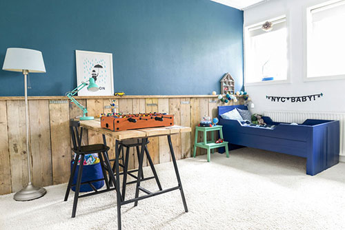stoere jongenskamer steigerhouten lambrisering blauwe muur tapijt