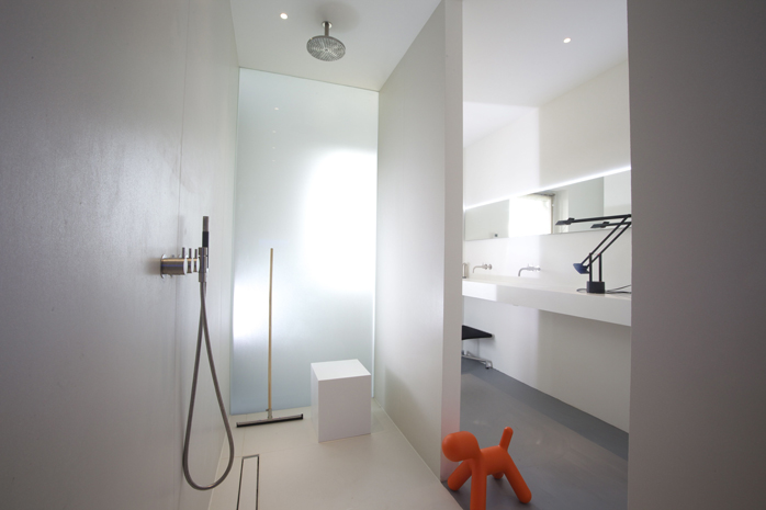 Melkglazen wand in inloopdouche van strakke moderne badkamer