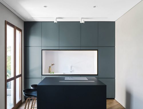 Strakke moderne keuken met blauwe wandkast en zwart kookeiland